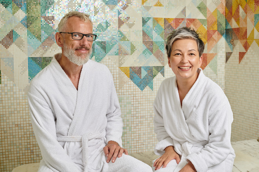 Photo of happy senior couple in front of custom tiles.